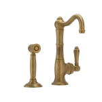 Raw Brass kitchen faucet with spray head on a white background